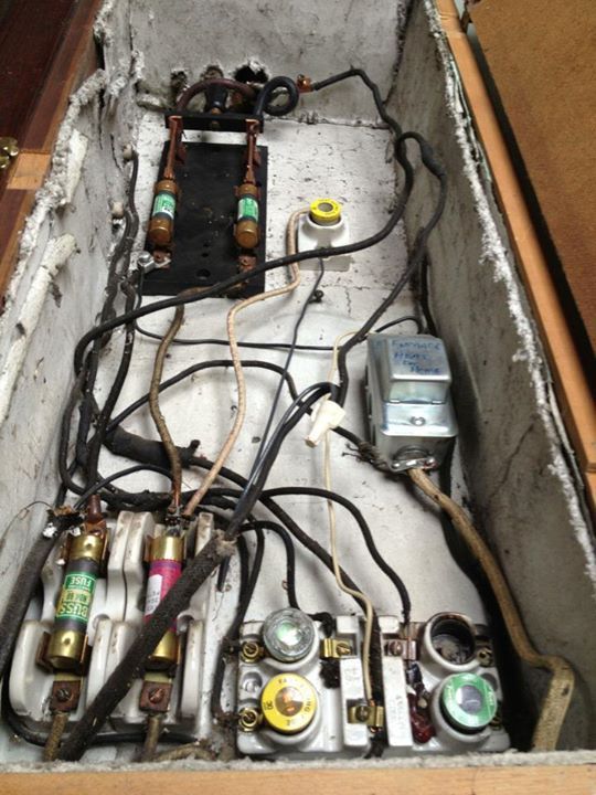 An old fuse box full of cloth-covered wiring