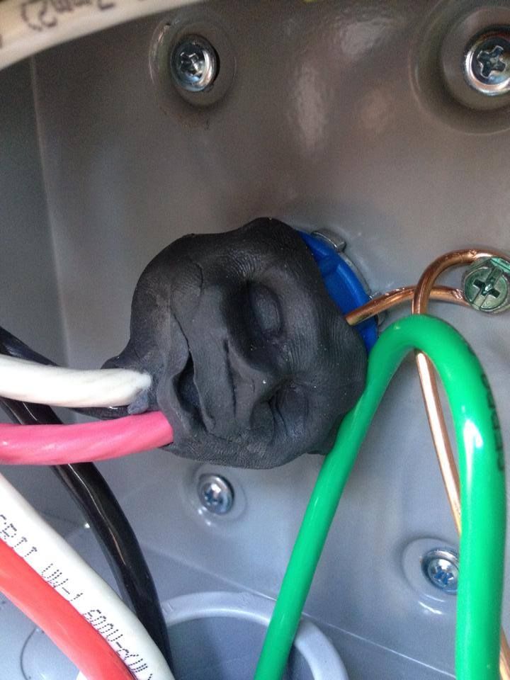 Close-up of a conduit entry packed with black duct seal around conductors
