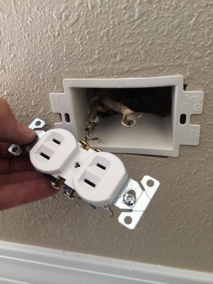 An old two-prong outlet being swapped for a new one