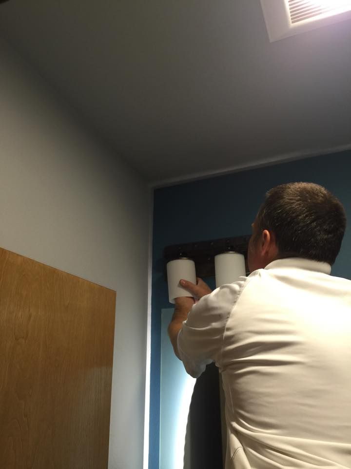 Robert on a step stool wiring a bathroom vanity light