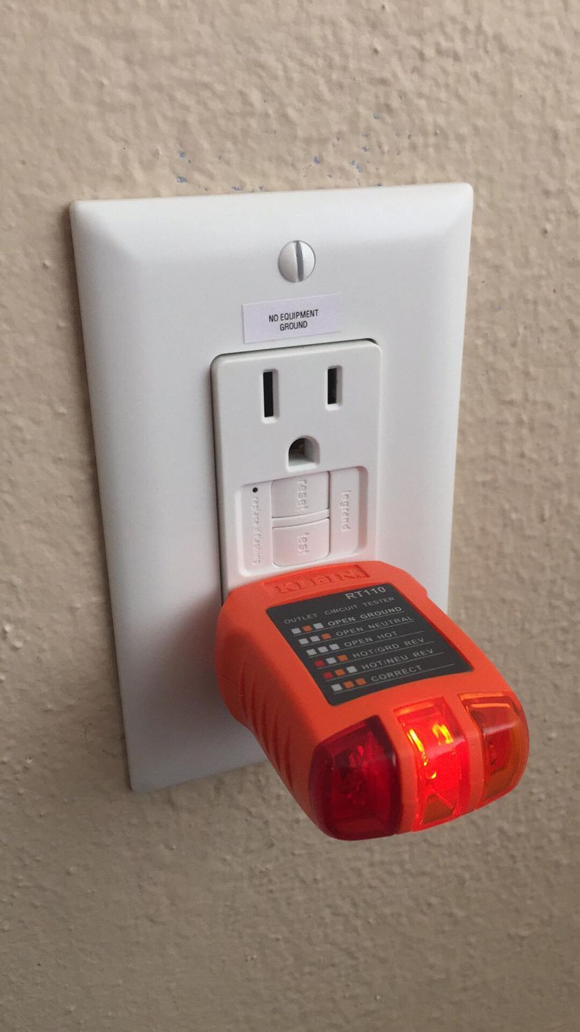A GFCI with a tester and a No Equipment Ground label